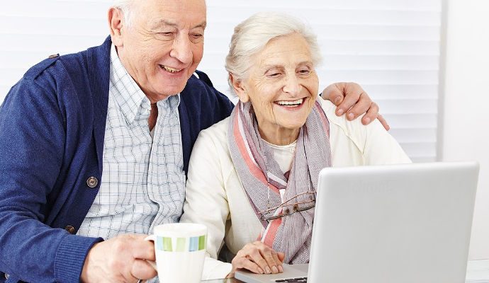 Starší manželé u notebooku řeší financování svého bydlení